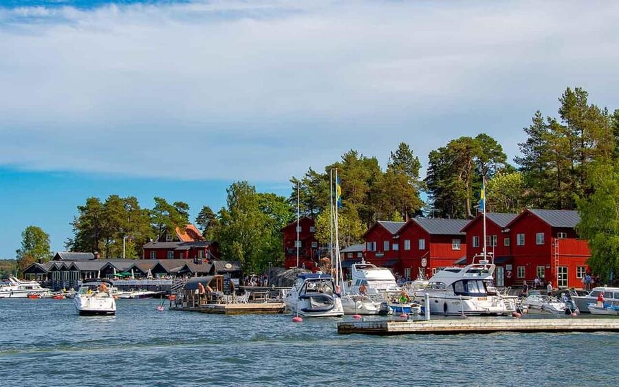 Red boathouses and moored boats on an island in the Stockholm archipelago